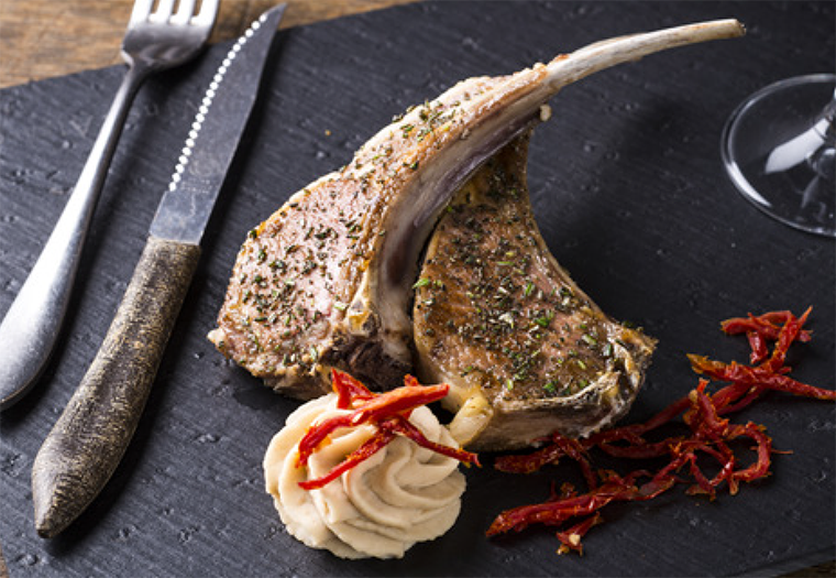 Lamb ribs in herb crust on white bean hummus, Dijon mustard and grilled garlic